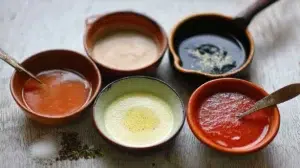 french sauces hollandaise bechamel demi-glace in copper saucepan with egg yolks lemon and butter on marble