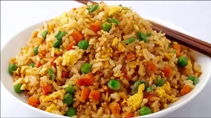 hinese fried rice recipe being tossed in smoking carbon steel wok with shrimp char siu pork peas and spring onion showing golden separated grains