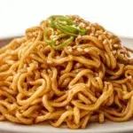 Cold sesame noodles tossed in a creamy sesame sauce and topped with green onions, sesame seeds, and fresh vegetables.