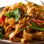 Spicy drunken noodles stir-fried with tender vegetables, fresh basil, and a savory Thai-inspired sauce.