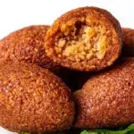 Kibbeh with crispy bulgur shell and savory seasoned meat filling served on a plate