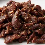 Korean bulgogi with thinly sliced marinated beef cooked until caramelized and topped with sesame seeds
