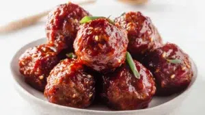 Korean gochujang meatballs glazed in spicy sweet sauce and garnished with sesame seeds and green onions