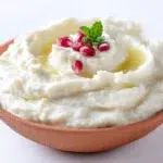 Creamy mutabbal dip made with roasted eggplant, tahini, olive oil, and garnished with fresh parsley and pomegranate seeds.