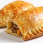 Golden Nigerian meat pies with flaky pastry crusts filled with seasoned minced meat, potatoes, and vegetables.