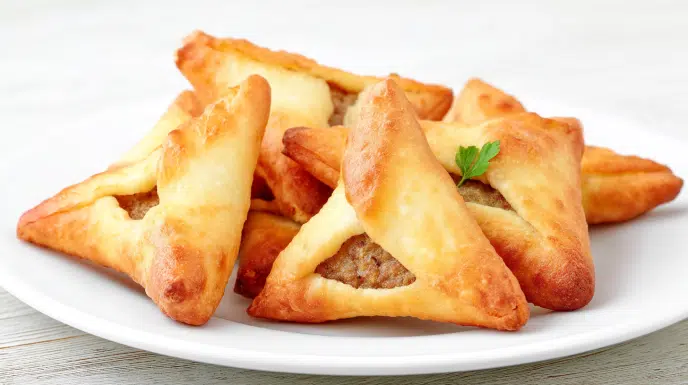 sfeeha recipe crispy golden lebanese spiced meat pies on parchment lined tray with yogurt dipping sauce fresh parsley and lemon wedge