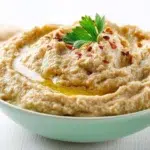 Baba ghanoush served in a bowl with olive oil, herbs, and roasted eggplant texture