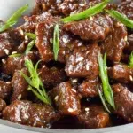 Tender Mongolian beef stir-fried in a glossy savory sauce with green onions and served over steamed rice.