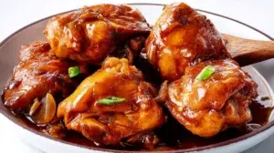 Chicken adobo simmered in a rich savory sauce with garlic, soy sauce, and tender chicken pieces.