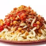 Egyptian koshari served in a bowl with rice, lentils, pasta, crispy onions, and a flavorful tomato sauce.