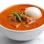 Ghanaian groundnut soup served in a bowl with a rich peanut-based broth, tender meat, and aromatic spices.