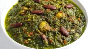 Ghormeh Sabzi herb stew simmered with fresh herbs, tender beef, kidney beans, and dried limes in a rich broth.