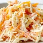 Japanese kani salad made with shredded crab sticks, crisp cucumber, and a creamy sesame dressing, garnished with sesame seeds.