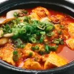 Korean soft tofu stew served bubbling hot with silky tofu, vegetables, and a spicy flavorful broth.