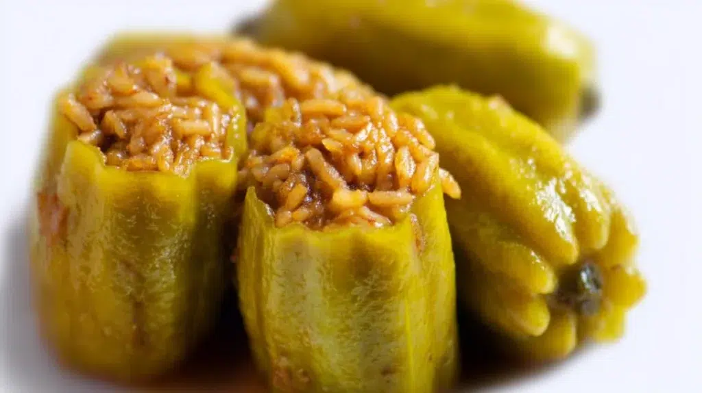 Kousa Mahshi made with tender zucchini stuffed with seasoned rice and meat, simmered in a rich tomato broth.