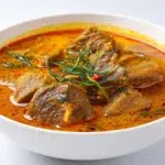 Traditional Banga soup made with palm fruit extract, tender meat, and fish, served in a rich flavorful broth.