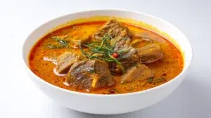 Traditional Banga soup made with palm fruit extract, tender meat, and fish, served in a rich flavorful broth.