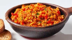 Turkish menemen made with eggs, tomatoes, peppers, and herbs, served warm in a traditional skillet.