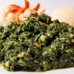 Traditional Ndole served in a bowl, featuring bitter greens, peanuts, and tender meat in a rich savory sauce.