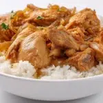 Chicken Yassa with tender marinated chicken, caramelized onions, and lemon sauce served over rice