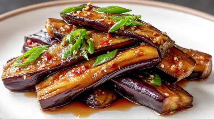 Chinese eggplant in garlic soy glaze cooked until tender, coated in a savory garlic soy sauce, and garnished with green onions and sesame seeds.