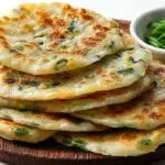 Chinese scallion pancakes pan-fried until crispy and golden with flaky layers and fresh green onions.