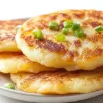 Korean potato pancakes pan-fried until crispy and golden, served with a savory dipping sauce.
