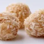 Nigerian coconut candy made with caramelized coconut pieces cut into bite-sized squares on a serving plate