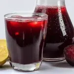 Nigerian Zobo juice served chilled with hibiscus, citrus slices, and ice in a glass
