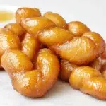 South African koeksisters braided and fried until golden, then soaked in a sweet syrup with a glossy finish.