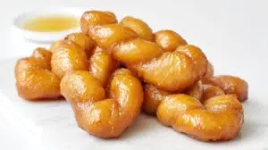 South African koeksisters braided and fried until golden, then soaked in a sweet syrup with a glossy finish.
