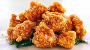 Taiwanese popcorn chicken fried until golden and crispy, seasoned with aromatic spices, and garnished with fresh basil leaves.