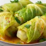 Thai coconut curry cabbage rolls filled with seasoned vegetables and protein in a creamy coconut curry sauce