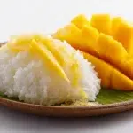 Thai mango sticky rice served with sweet coconut sticky rice, fresh ripe mango slices, and a drizzle of creamy coconut sauce.