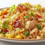 Thai pineapple chicken fried rice with tender chicken, pineapple chunks, vegetables, and jasmine rice garnished with green onions