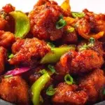Indian chilli chicken made with crispy chicken pieces tossed in a spicy, savory sauce with peppers and onions.