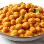 Indian butter chickpeas in a creamy tomato curry sauce garnished with fresh cilantro and served with rice