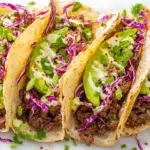 Korean beef tacos with marinated beef, fresh vegetables, sesame seeds, and Korean-inspired sauce in soft tortillas