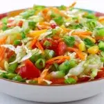 Nigerian vegetable salad with lettuce, cabbage, carrots, cucumbers, tomatoes, sweet corn, boiled eggs, and creamy dressing