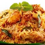 Chicken biryani with fragrant basmati rice, tender spiced chicken, and fresh herbs served on a platter